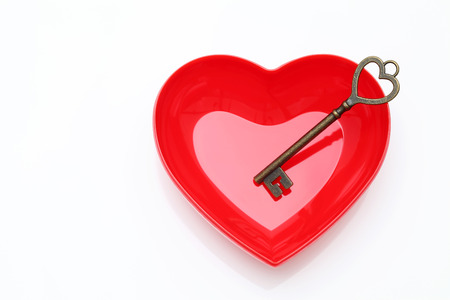 vintage key and red heart on white backgroundの写真素材