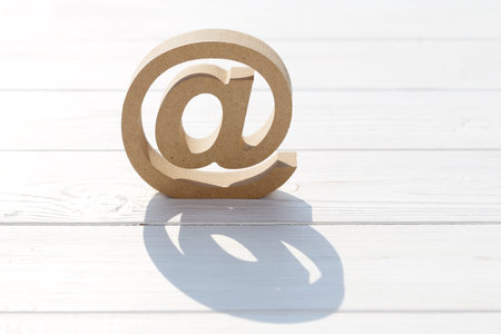 Wooded email symbol on white table, white backgroundの写真素材