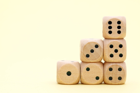 Stacked wooden dice on a yellow backgroundの写真素材