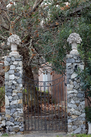Old iron gate between two masonry brick pillarsの写真素材