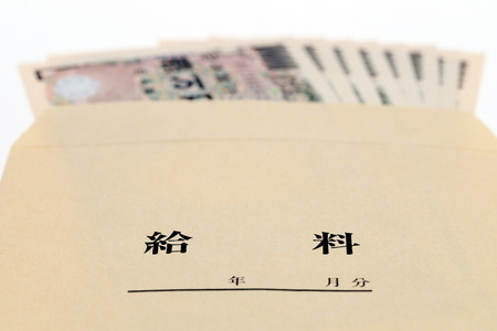 Japanese money in salary envelope on white backgroundの写真素材
