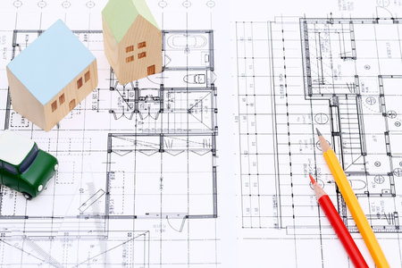 Miniature model of house and blueprints, construction plan