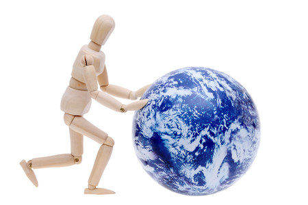 wooden model dummy hand rolling globe isolated on white backgroundの写真素材