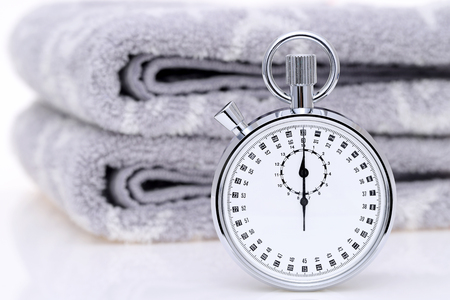 analogue stopwatch with facecloth on white backgroundの写真素材