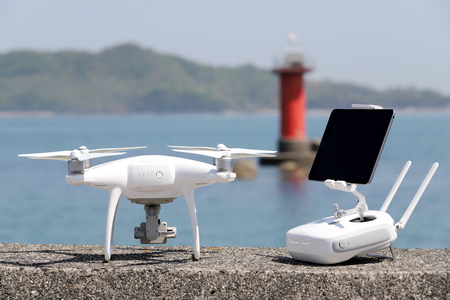 drone and remote controller with monitor on concrete jetty