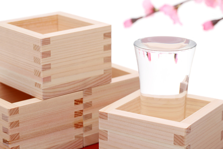 Japanese wooden box masu with sake on white backgroundの写真素材