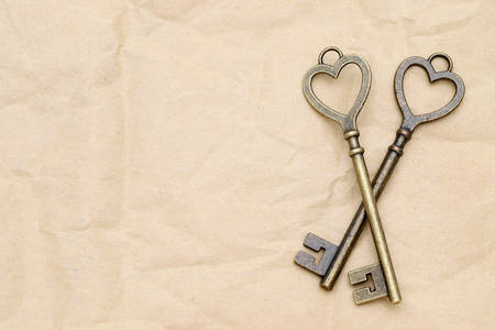 heart shaped vintage golden key on brown paper backgroundの写真素材