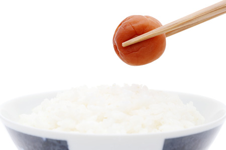 Japanese cooked white rice with Umeboshi on white backgroundの写真素材