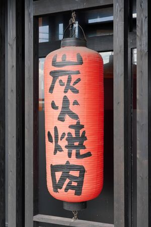 Red paper lanterns advertising grilled meat restaurant, The sign readsの写真素材