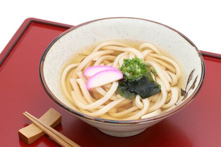 Japanese Kake udon noodles in a ceramic bowl on white backgroundの写真素材
