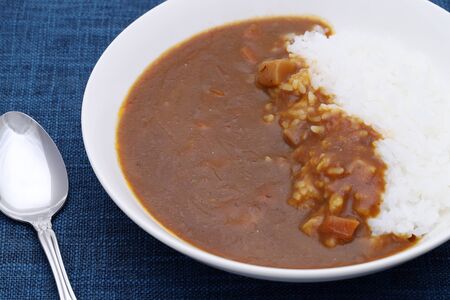 Close up of curry rice with spoon on tableの写真素材