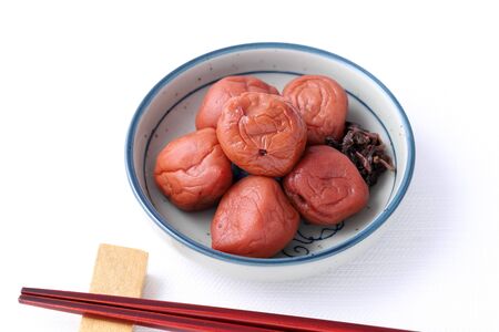 Japanese food, salted Umeboshi in a dish on white backgroundの写真素材