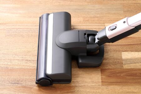 Head of modern vacuum cleaner on wooden floorの写真素材