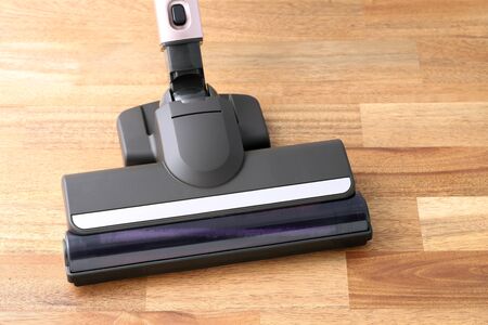 Head of modern vacuum cleaner on wooden floorの写真素材