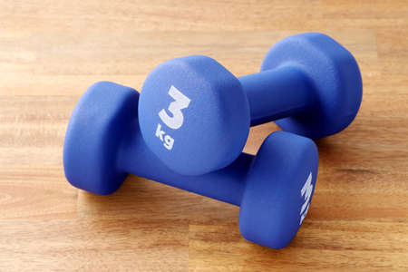 Two pairs of blue fitness dumbbells on wooden floor, Concept healthy lifestyle, sport and diet. Sport equipment.の写真素材