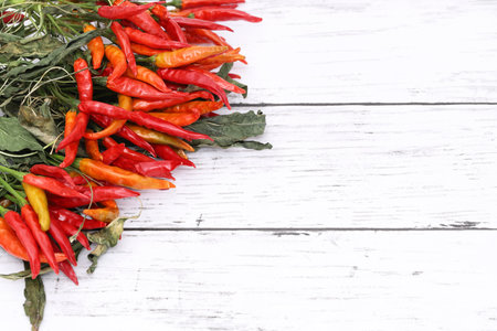 Dried red chili pepper plants on white wooden tableの写真素材