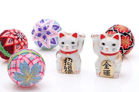 Japanese lucky cat with Temari ball on white background, Japanese word of this photography means "blessing, economic fortune"の写真素材