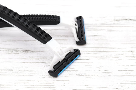 disposable shaving razor on white wooden tableの写真素材