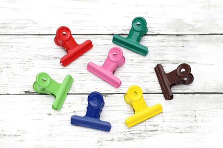 Colorful paper clips on white grunge wooden tableの写真素材