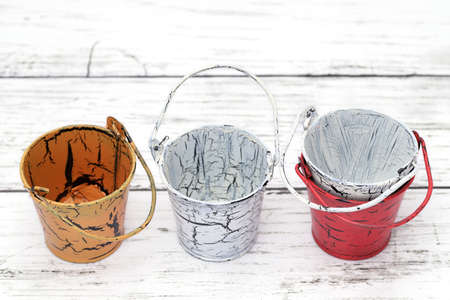 Empty miniature metal bucket on white wooden tableの写真素材