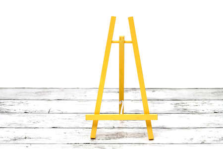 Wooden small easel on a white grunge wooden tableの写真素材