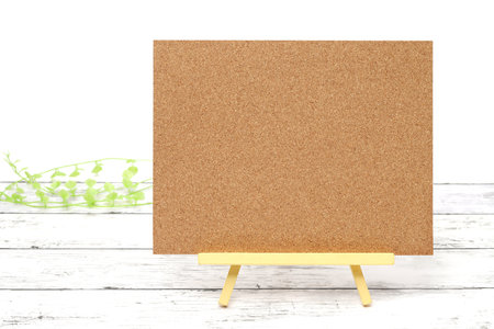 Wooden easel and blank board on a white wooden tableの写真素材