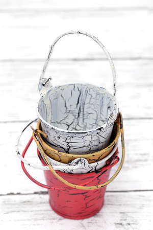 Empty miniature metal bucket on white wooden tableの写真素材
