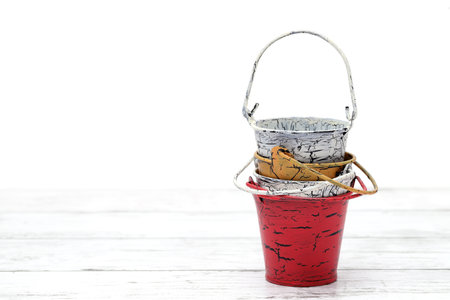 Empty miniature metal bucket on white wooden tableの写真素材