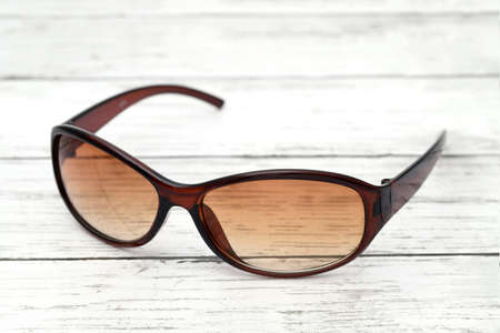Ladies fashion sunglasses on a white wooden tableの写真素材