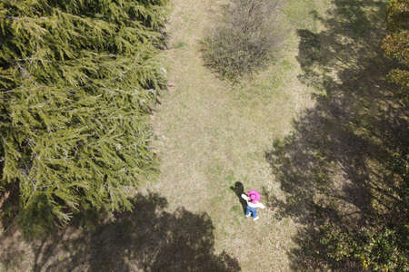 A woman in a pink hat in the forest, shooting from a drone. Vacation, Summerの写真素材