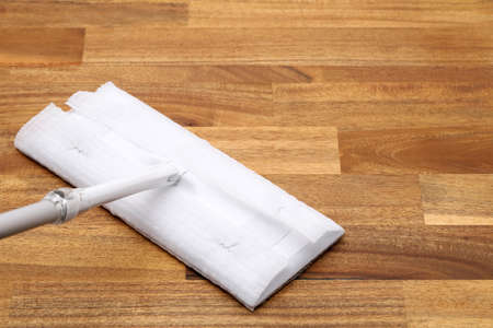 Part of flat wet paper mop and disposable working head on wooed floorの写真素材