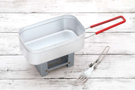New aluminum mestin with mini stove on a white wooden tableの写真素材