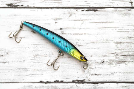 Plastic fishing lure on a white wooden tableの写真素材