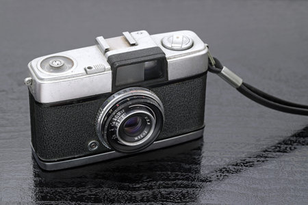 close up of old film camera on black background