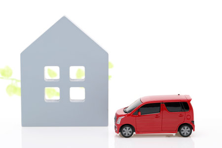 Wooden toy house and toy car isolated on white backgroundの写真素材
