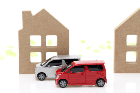 Wooden toy house and toy car isolated on white backgroundの写真素材