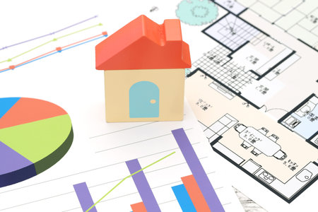 Toy house and color chart printed documents, blueprint close up image on the table.