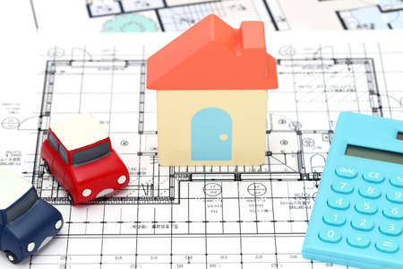 Small toy car and wooden toy house close up image on blueprint backgroundの写真素材
