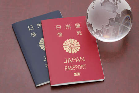 Japanese passport with glass globe on red leather backgroundの写真素材