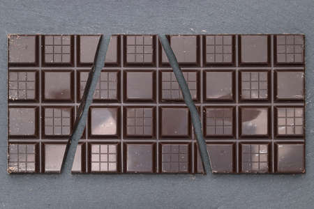 Cracked Dark Chocolate bar on a gray backgroundの写真素材