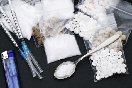 cooked heroin drugs and injection syringe on black backgroundの写真素材