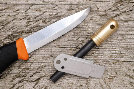 fire starter and camping knife on grungy wooden backgroundの写真素材