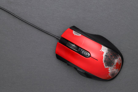 broken computer mouse with connection cable on dark gray background