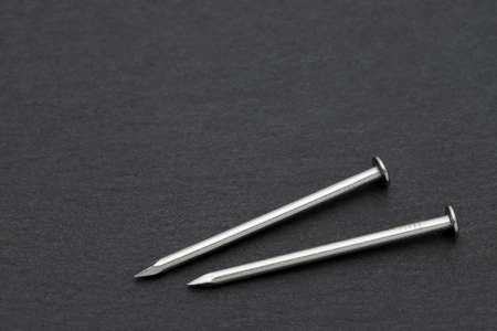 silver metallic nails on black backgroundの写真素材