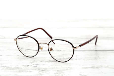 Stylish brown framed glasses on a white wooden tableの写真素材