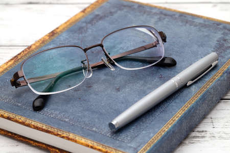 Stylish eyesight glasses and diary book on white wooden tableの写真素材