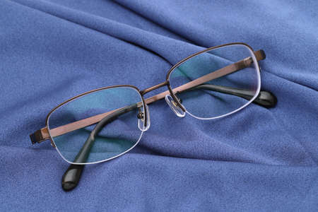 Stylish eyesight glasses and blue glass cleaning cloth backgroundの写真素材