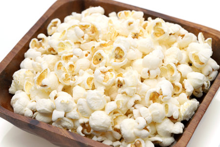 Popcorn in wooden bowl on white background, Side view, Close upの写真素材