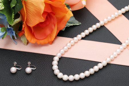Elegant white pearl necklace and earrings on black backgroundの写真素材