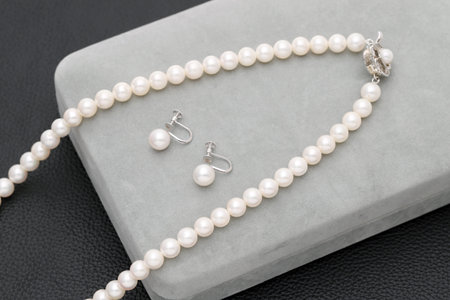 Elegant white pearl necklace and earrings on black backgroundãの写真素材